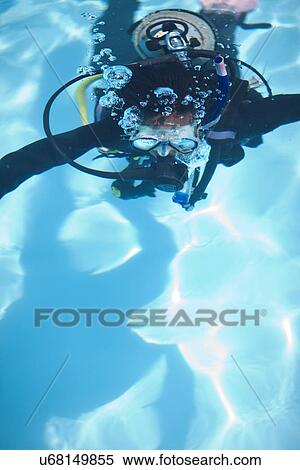 Stock Photography - Young female scuba diver training in swimming pool. Fotosearch