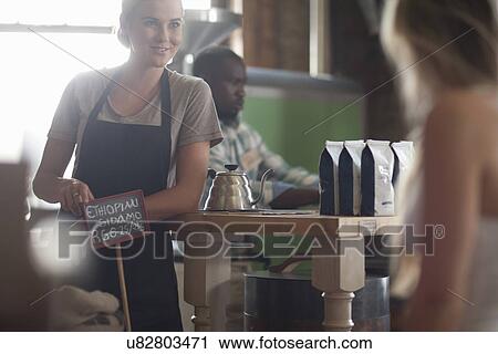 Young female waitress advising on coffee choice in cafe View Large Photo Image Stock Image - Young female waitress advising on coffee choice in cafe. Fotosearch
