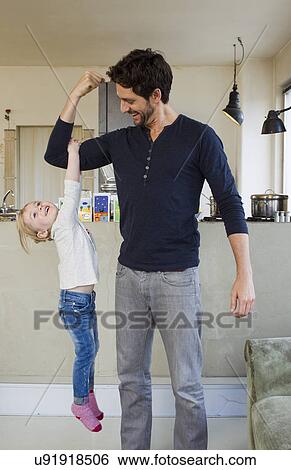 Young girl dangling from her fathers arm View Large Photo Image Stock Photograph - Young girl dangling from her fathers arm. Fotosearch