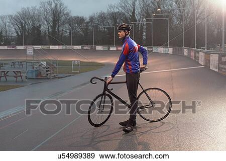 Young male cyclist at velodrome at night View Large Photo Image Stock Photo - Young male cyclist at velodrome at night. Fotosearch