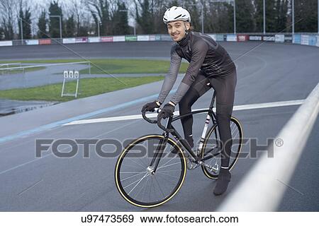 Stock Photo - Young male cyclist at velodrome finishing line. Fotosearch
