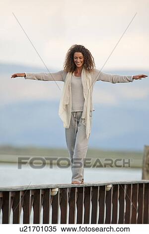 Young woman balancing on jetty View Large Photo Image Stock Photography - Young woman balancing on jetty. Fotosearch