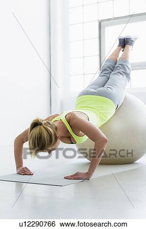 Young woman doing press up with exercise ball View Large Photo Image Stock Photograph - Young woman doing press up with exercise ball. Fotosearch