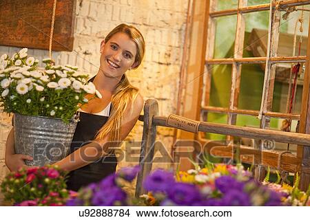 Young woman holding flowers View Large Photo Image Picture - Young woman holding flowers. Fotosearch