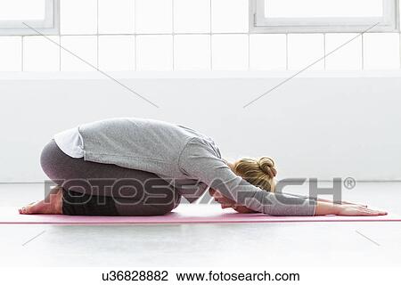 Young woman in yoga pose on yoga mat View Large Photo Image Stock Image - Young woman in yoga pose on yoga mat. Fotosearch