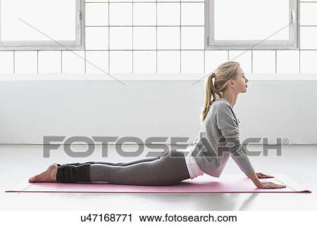 Young woman in yoga pose on yoga mat View Large Photo Image Stock Image - Young woman in yoga pose on yoga mat. Fotosearch