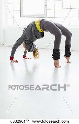 Stock Image - Young woman in yoga position. Fotosearch