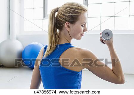 Young woman lifting weights View Large Photo Image Picture - Young woman lifting weights. Fotosearch