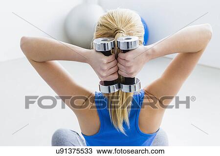Young woman lifting weights, rear view View Large Photo Image Stock Image - Young woman lifting weights, rear view. Fotosearch