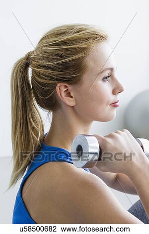 Young woman lifting weights View Large Photo Image Stock Image - Young woman lifting weights. Fotosearch