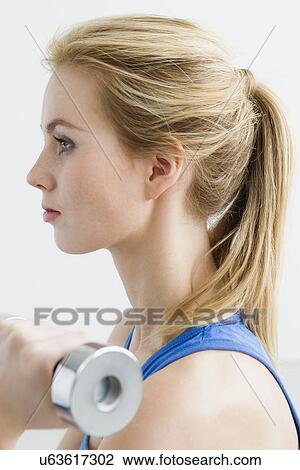 Young woman lifting weights View Large Photo Image Stock Image - Young woman lifting weights. Fotosearch