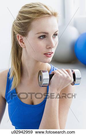 Young woman lifting weights View Large Photo Image Stock Photo - Young woman lifting weights. Fotosearch