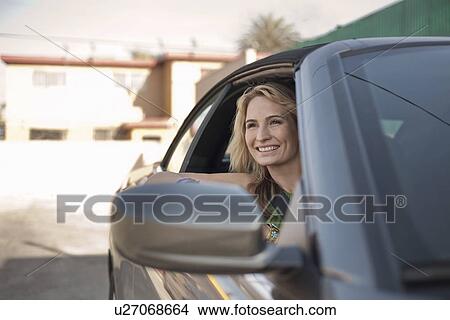Picture - Young woman looking out of car window. Fotosearch