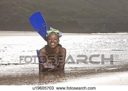 Young woman lying on beach, wearing snorkel View Large Photo Image Stock Image - Young woman lying on beach, wearing snorkel. Fotosearch