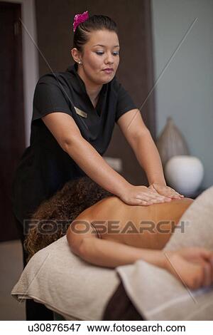 Young woman lying on front having a massage in spa View Large Photo Image Stock Photo - Young woman lying on front having a massage in spa. Fotosearch
