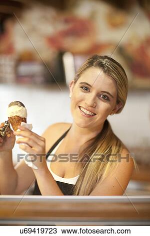 Young woman serving icecream View Large Photo Image Stock Image - Young woman serving icecream. Fotosearch