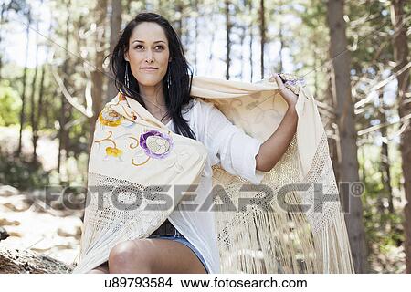Picture - Young woman sitting in forest. Fotosearch