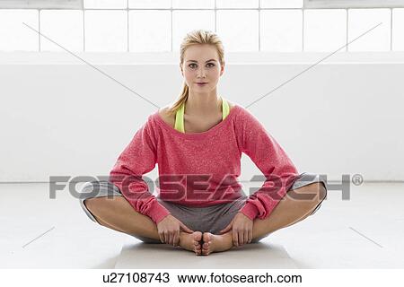 Young woman sitting on exercise mat View Large Photo Image Stock Image - Young woman sitting on exercise mat. Fotosearch