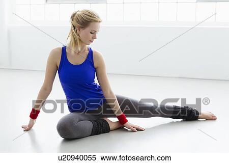 Young woman sitting on floor in gymnasium View Large Photo Image Stock Photography - Young woman sitting on floor in gymnasium. Fotosearch