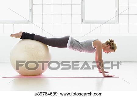 Young woman stretching on exercise ball View Large Photo Image Stock Photo - Young woman stretching on exercise ball. Fotosearch