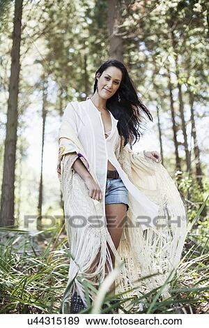Stock Photo - Young woman walking through forest. Fotosearch