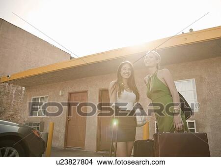 Young women with suitcases standing outside motel View Large Photo Image Picture - Young women with suitcases standing outside motel. Fotosearch