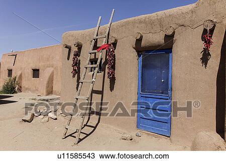 Stock Image - Adobe houses against blue sky at Taos; New Mexico; USA. Fotosearch