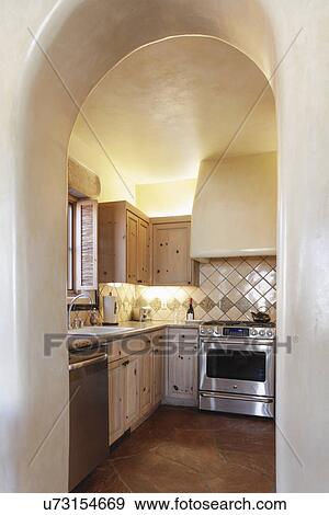 Arched way leading to kitchen with white cabinets at home; Santa Fe; New Mexico; USA View Large Photo Image Stock Photo - Arched way leading to kitchen with white cabinets at home; Santa Fe; New Mexico; USA. Fotosearch