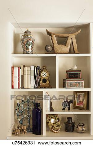 Stock Image - Books with centerpieces in shelf at home; Santa Fe; New Mexico; USA. Fotosearch