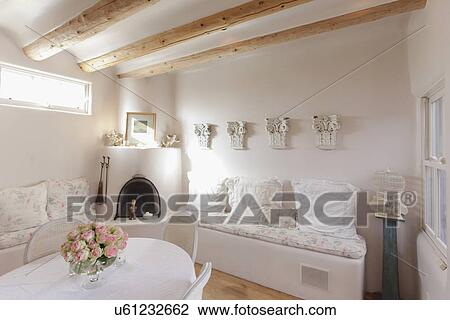 Stock Image - Built in couches with fireplace and cropped dining area; Santa Fe; New Mexico; USA. Fotosearch