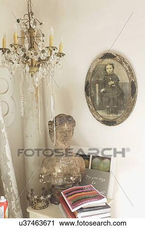 Stock Image - Close-up of an old bust with books and hanging light at home; Santa Fe; New Mexico; USA. Fotosearch