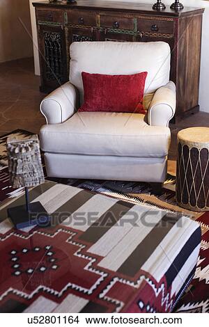 Picture - Close-up of cropped coffee table with upholstered armchair in living room; Santa Fe; New Mexico; USA. Fotosearch