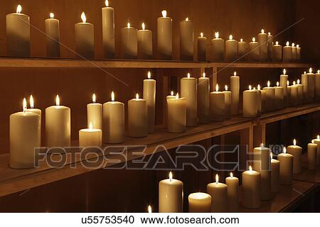 Stock Image - Close-up of lit candles on shelves; Santa Fe; New Mexico; United States. Fotosearch