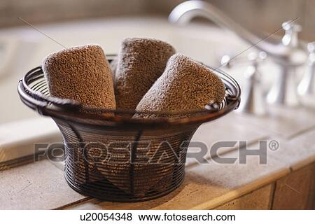 Close-up of rolled towels in basket on countertop in the bathroom at home View Large Photo Image Stock Photo - Close-up of rolled towels in basket on countertop in the bathroom at home. Fotosearch