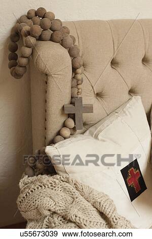 Stock Photo - Close-up rosary with throw pillow and shawl on cropped couch; Santa Fe; New Mexico; USA. Fotosearch