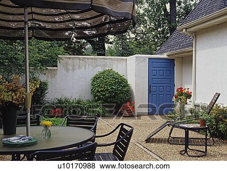 Courtyard area with high stucco walls; bright blue door and patio furniture View Large Photo Image Stock Photo - Courtyard area with high stucco walls; bright blue door and patio furniture. Fotosearch