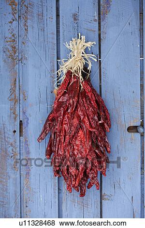Stock Photo - Detail shot of chili ristra hanging on closed door; Santa Fe; New Mexico; USA. Fotosearch