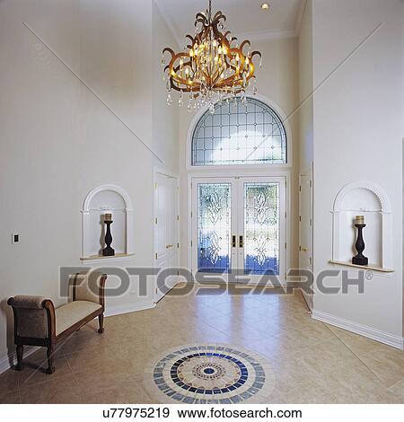 Stock Photo - Entry hall with white walls; mosaic pattern on floor and chandelier. Fotosearch