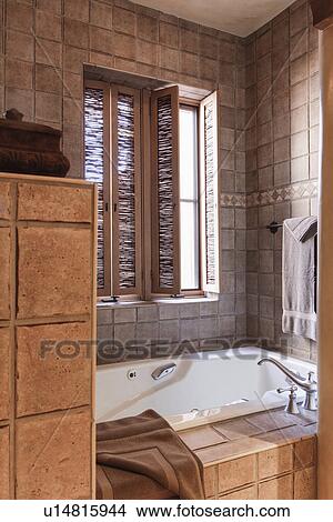 Picture - Faucet and bath by window in the bathroom; Santa Fe; New Mexico; USA. Fotosearch