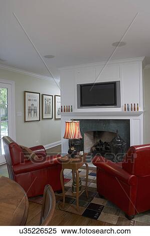 Fireplace With Tv Over Mantel And Rust Red Leather Club Chairs At