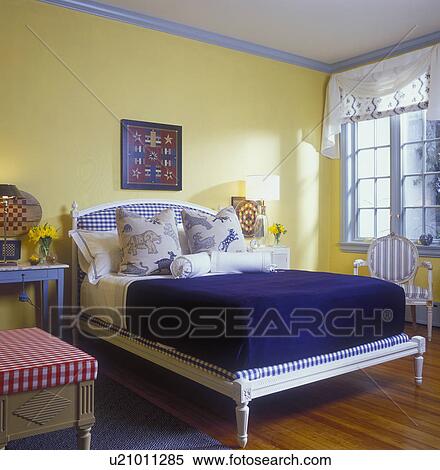 Stock Photography - Game boards on yellow walls with Swedish style bed at home. Fotosearch