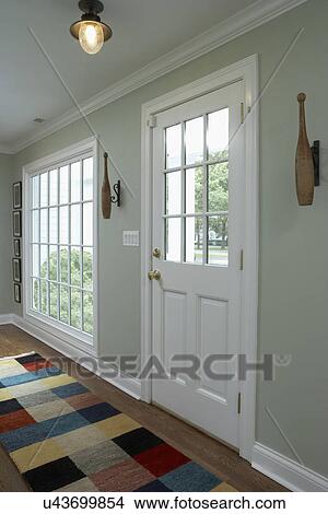 Picture - Hallway with color blocked area rug and French closed doors. Fotosearch
