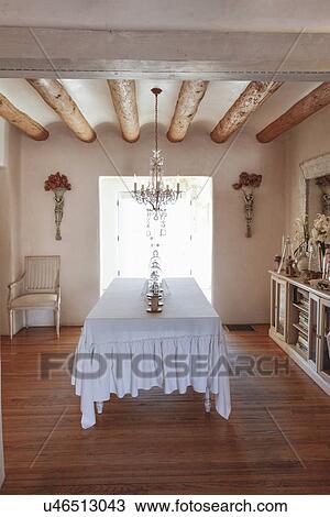 Stock Image - Hanging light over table with wooden floor at home; Santa Fe; New Mexico; USA. Fotosearch