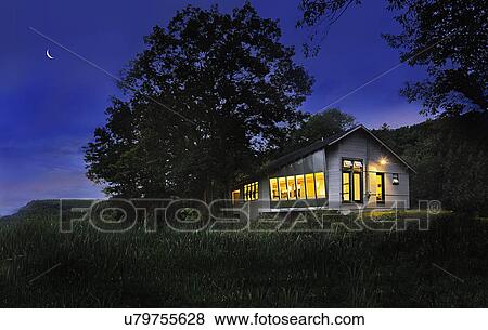 Stock Photo - Illuminated cabin with clapboard siding on landscape at night; Burlington; Vermont; USA. Fotosearch