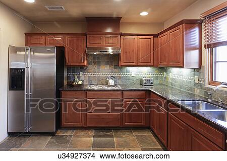 Kitchen with brown cabinets and stainless steel refrigerator; Santa Fe; New Mexico; USA View Large Photo Image Picture - Kitchen with brown cabinets and stainless steel refrigerator; Santa Fe; New Mexico; USA. Fotosearch