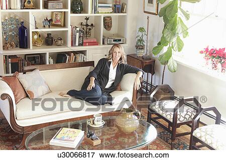 Portrait of a smiling woman relaxing in living room at home; Santa Fe; New Mexico; USA View Large Photo Image Stock Photo - Portrait of a smiling woman relaxing in living room at home; Santa Fe; New Mexico; USA. Fotosearch
