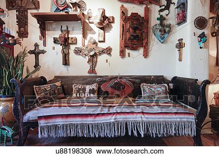 Stock Photo - Sofa with a variety of crosses on the wall at store; Taos; New Mexico; USA. Fotosearch