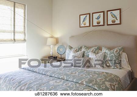 Stock Photograph - Table lamp by tidy bed in the bedroom at home; Santa Fe; New Mexico; USA. Fotosearch