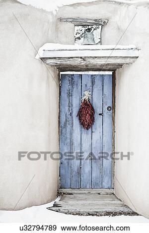 Stock Photo - Traditional chili ristra hanging on closed door; Santa Fe; New Mexico; USA. Fotosearch