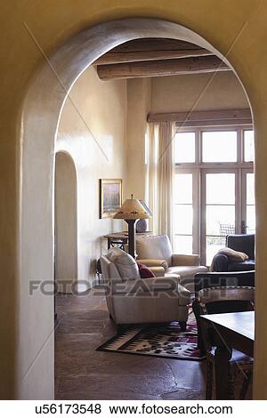 Stock Photo - View of living room through arched entrance at home; Santa Fe; New Mexico; USA. Fotosearch